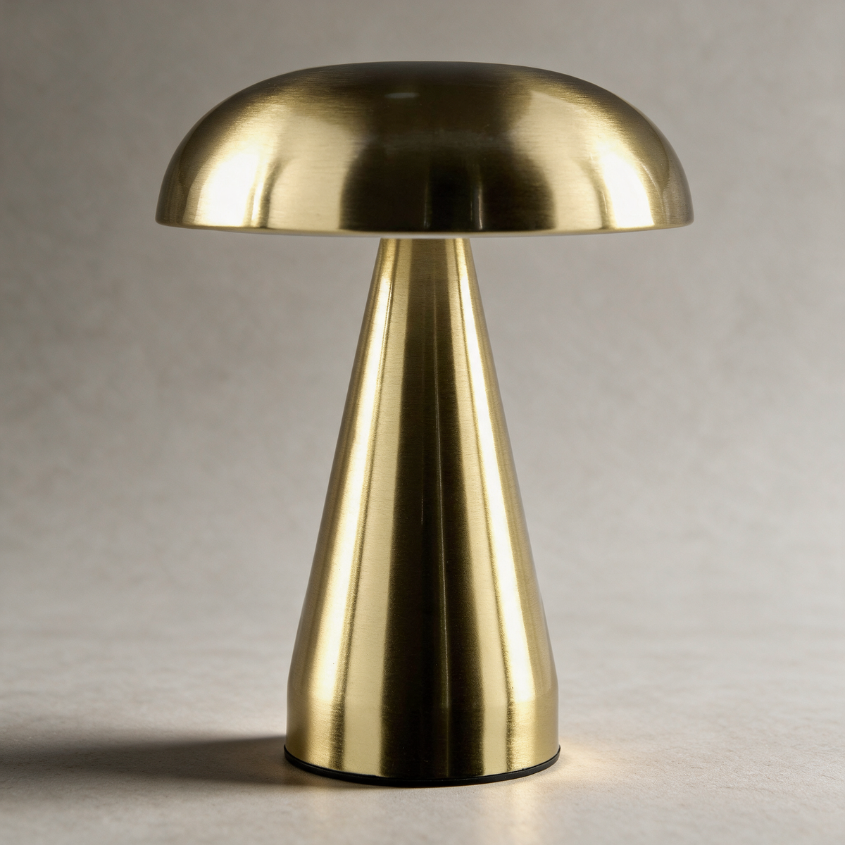 Brass table lamp on a warm grey studio background