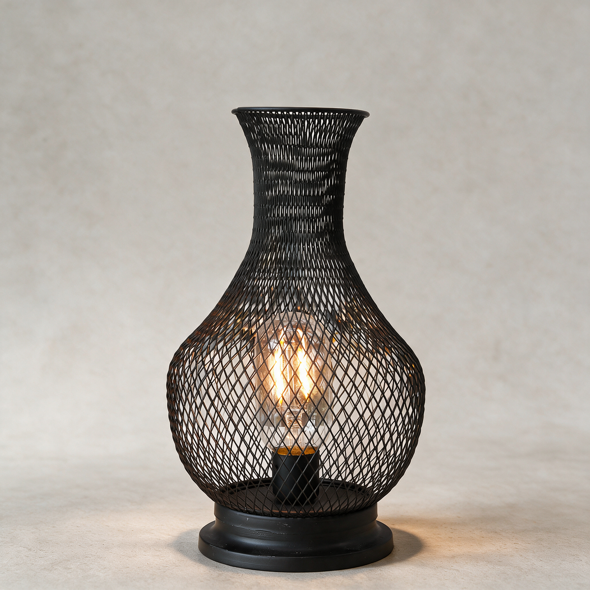Battery Edison cage lamp on a warm grey studio background