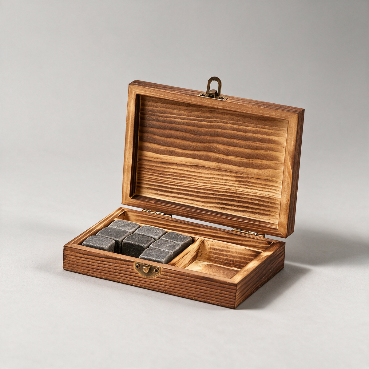 Wooden box of whiskey stones on a warm grey studio background