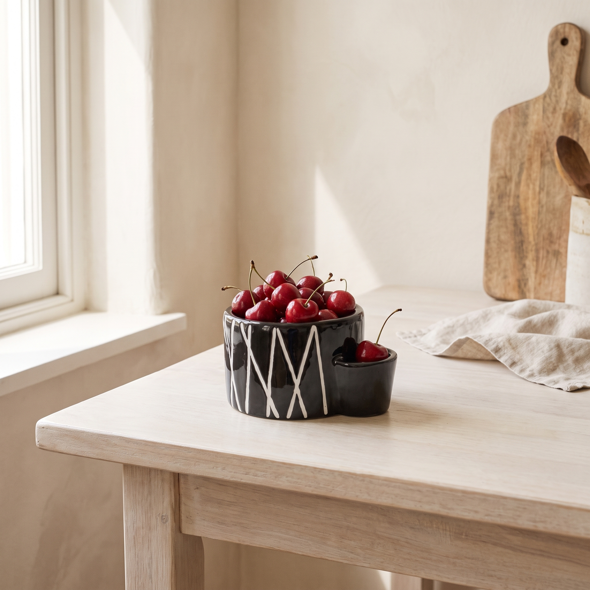Ceramic Bowl, Onyx on a kitchen table filled with cherries