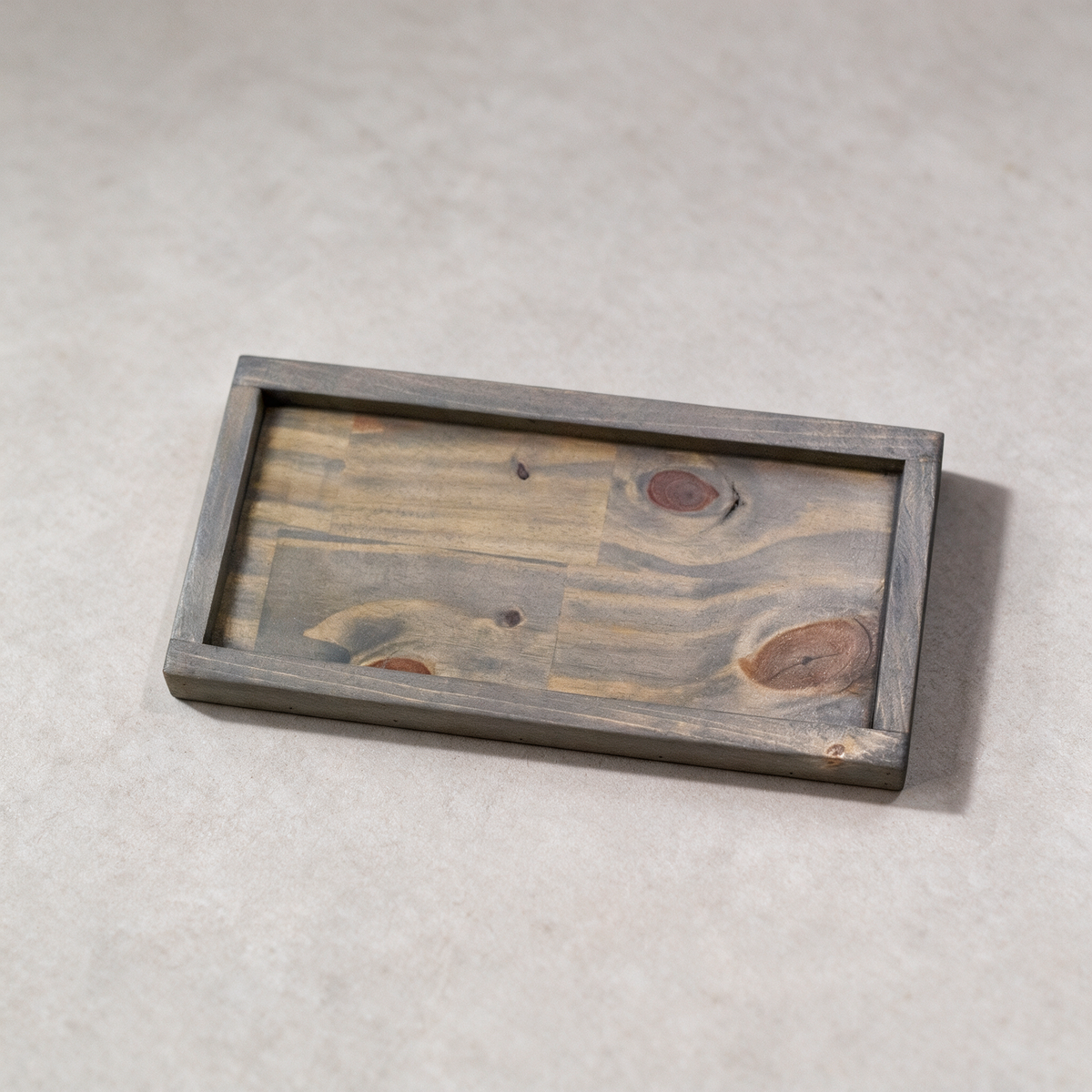 Wooden ottoman tray on a warm grey studio background