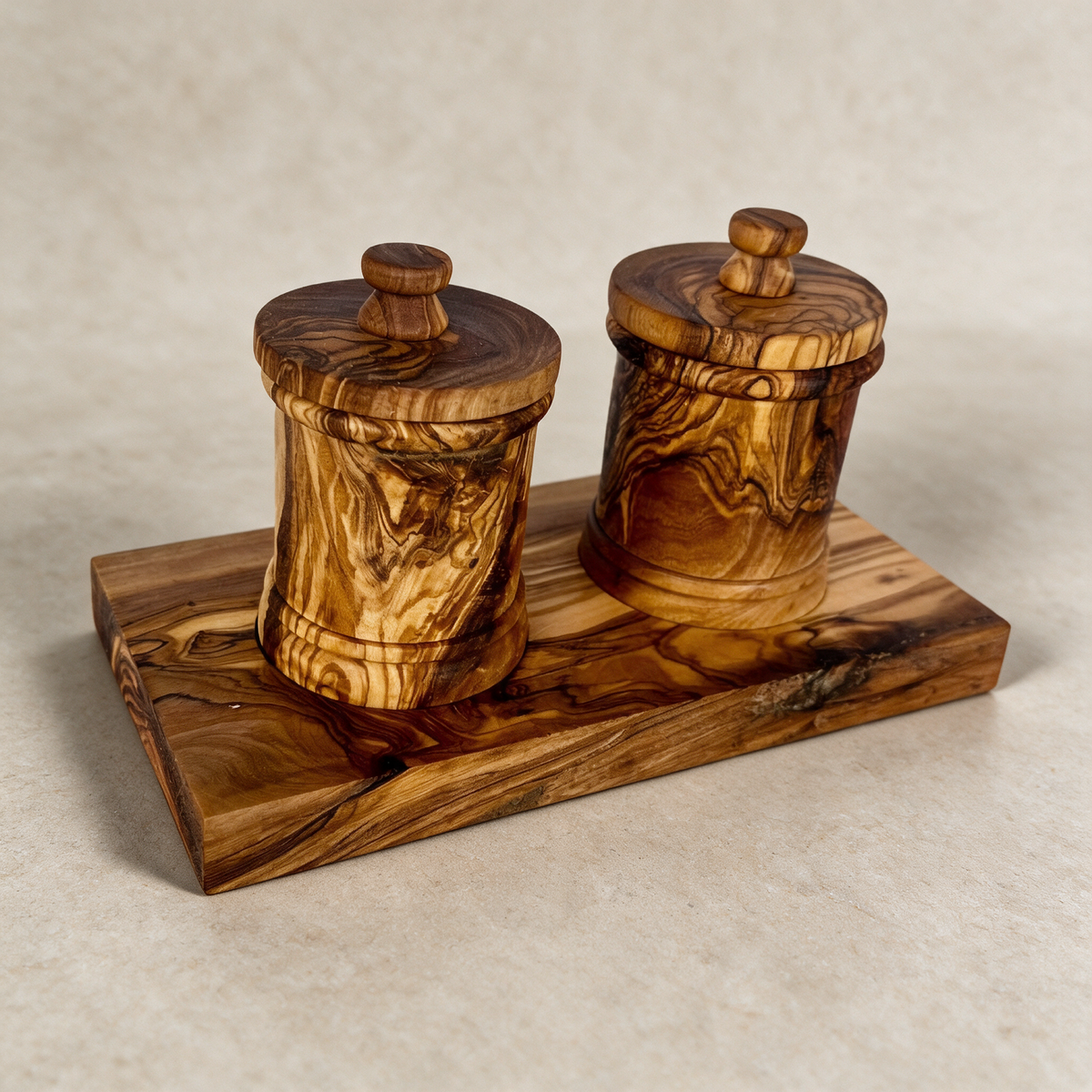 Olive wood canister set on a warm grey studio background