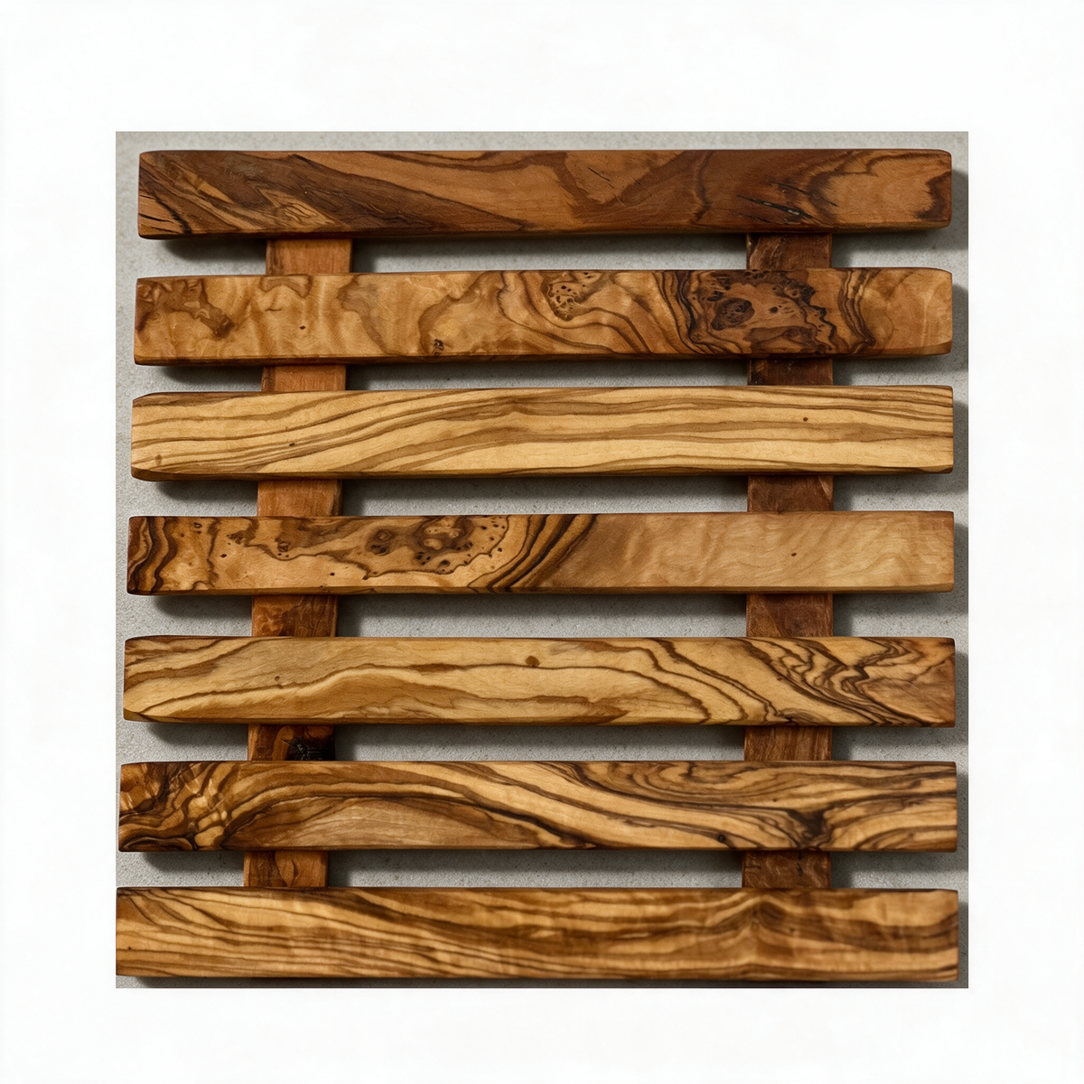 Olive wood trivet on a warm grey studio background
