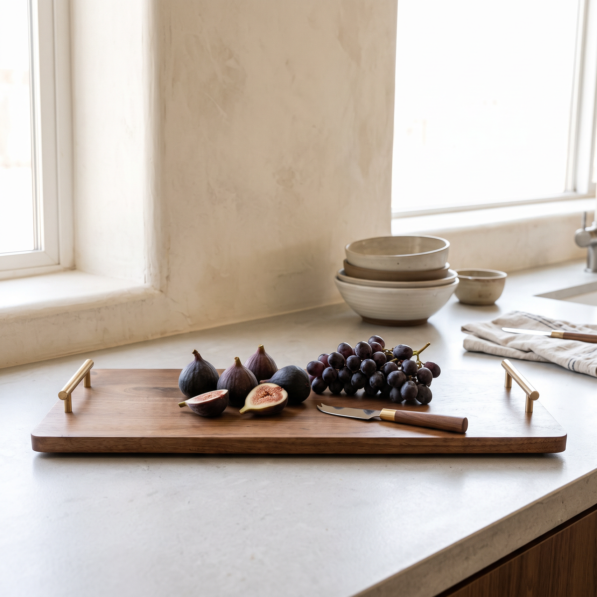 Walnut Serving Board, Extra Large on a kitchen counter with figs and grapes